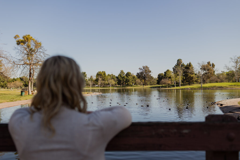 Midlife woman gazing at a lake in a park