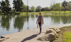 Woman walking by a lake at a park